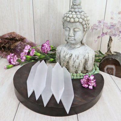Selenite Flat Double Points with decorations in the background