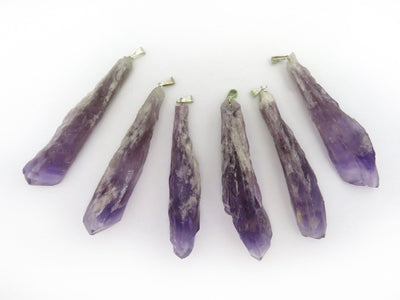 multiple elestial point amethyst pendants displayed to show the differences in the sizes