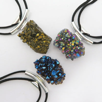multiple crystal cluster necklaces with a titanium finish displayed to show the differences in the color shades 