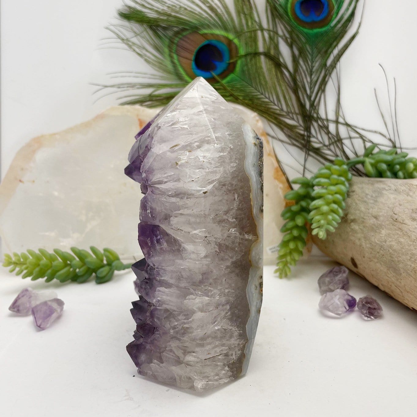 side view of Amethyst Crystal Cluster Polished Point with decorations in the background