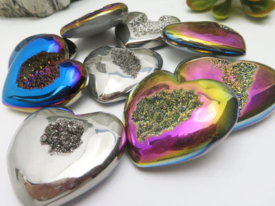 Titanium Druzy Hearts in mystic blue, platinum and rainbow laid out  on a table up close