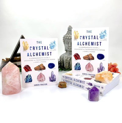 the crystal alchemist books with some crystals surrounding the books on a white background