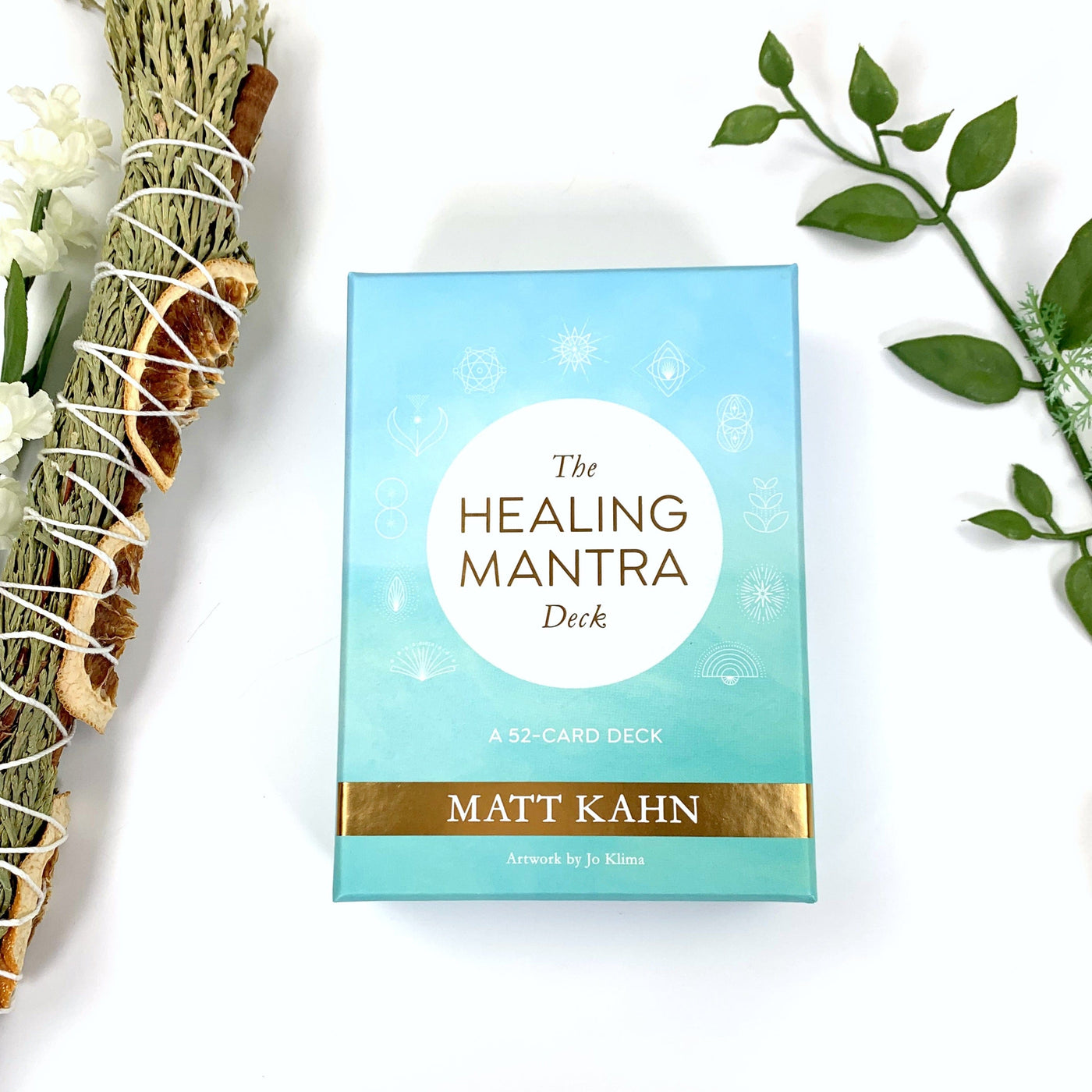 The front of the  The Healing Mantra Deck  box in a teal blue color