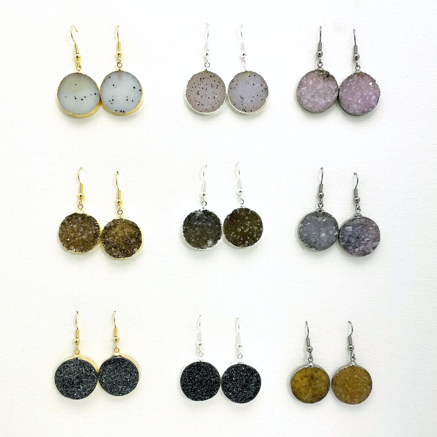 9 assorted round druzy earrings with silver and gold earwires.  Druzy colors range and are white, white with black spots, light purple, various shades of brown and tan, various shades of gray and orange brown.  Two of the earrings on the last row are titanium treated and sparkly black.