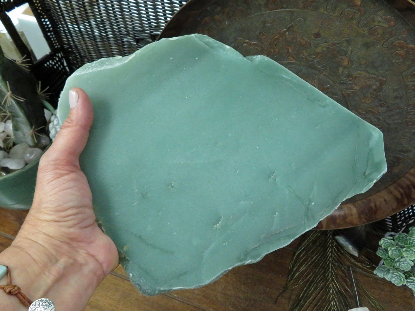 close up of green quartz platter in a hand