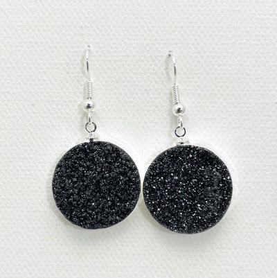Close up of black titanium druzy earrings with silver plating.