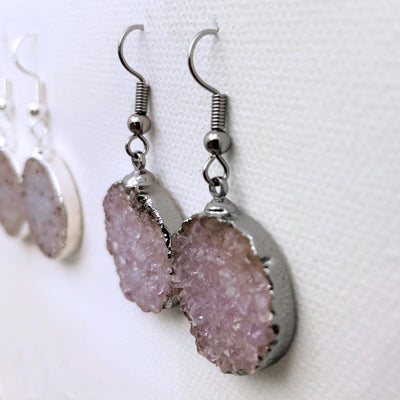 Side view of silver plated druzy round earring showing that it is plated around the edges and has silver plated earwires.