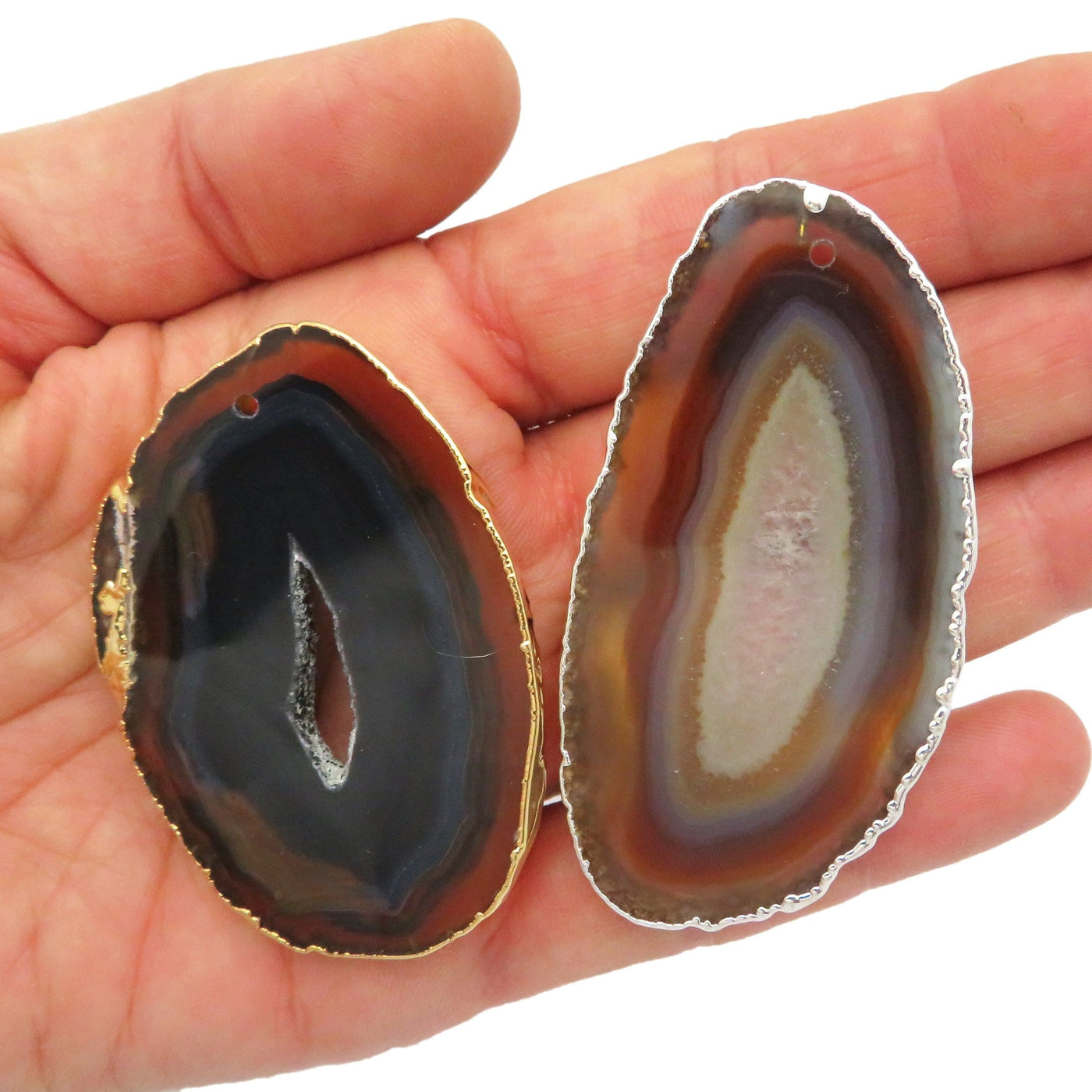 Picture of our two black agate slices plated edge, silver and gold being displayed.