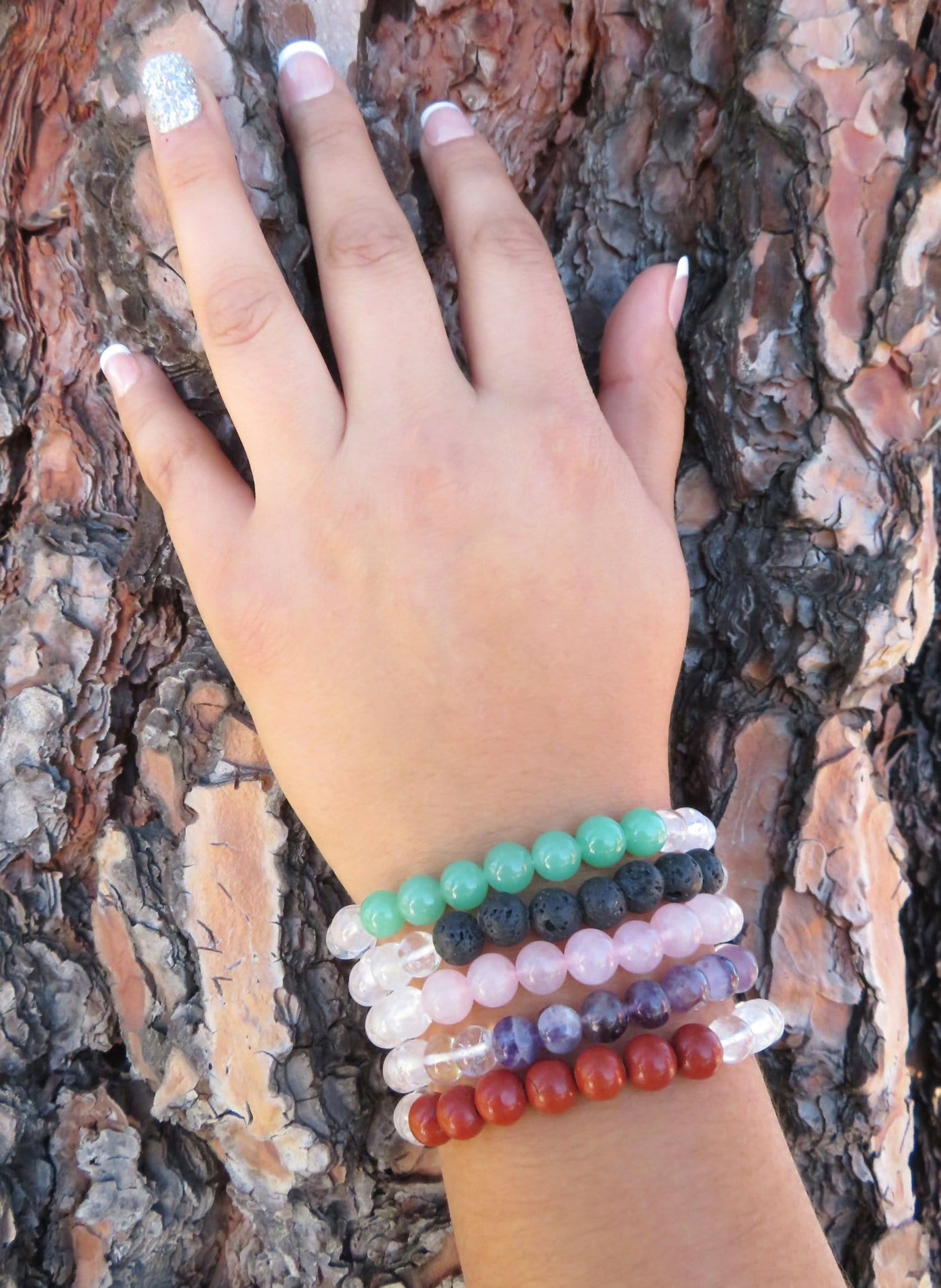 healing stone bracelets being warn to show size on a white background