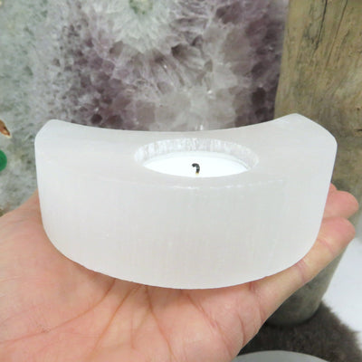 side view of selenite crescent moon candle holder in hand for thickness
