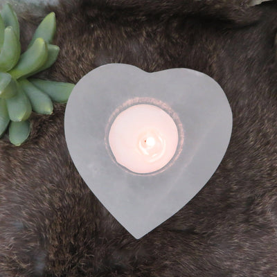 overhead view of selenite heart shaped candle holder with candle (not included with purchase) for details