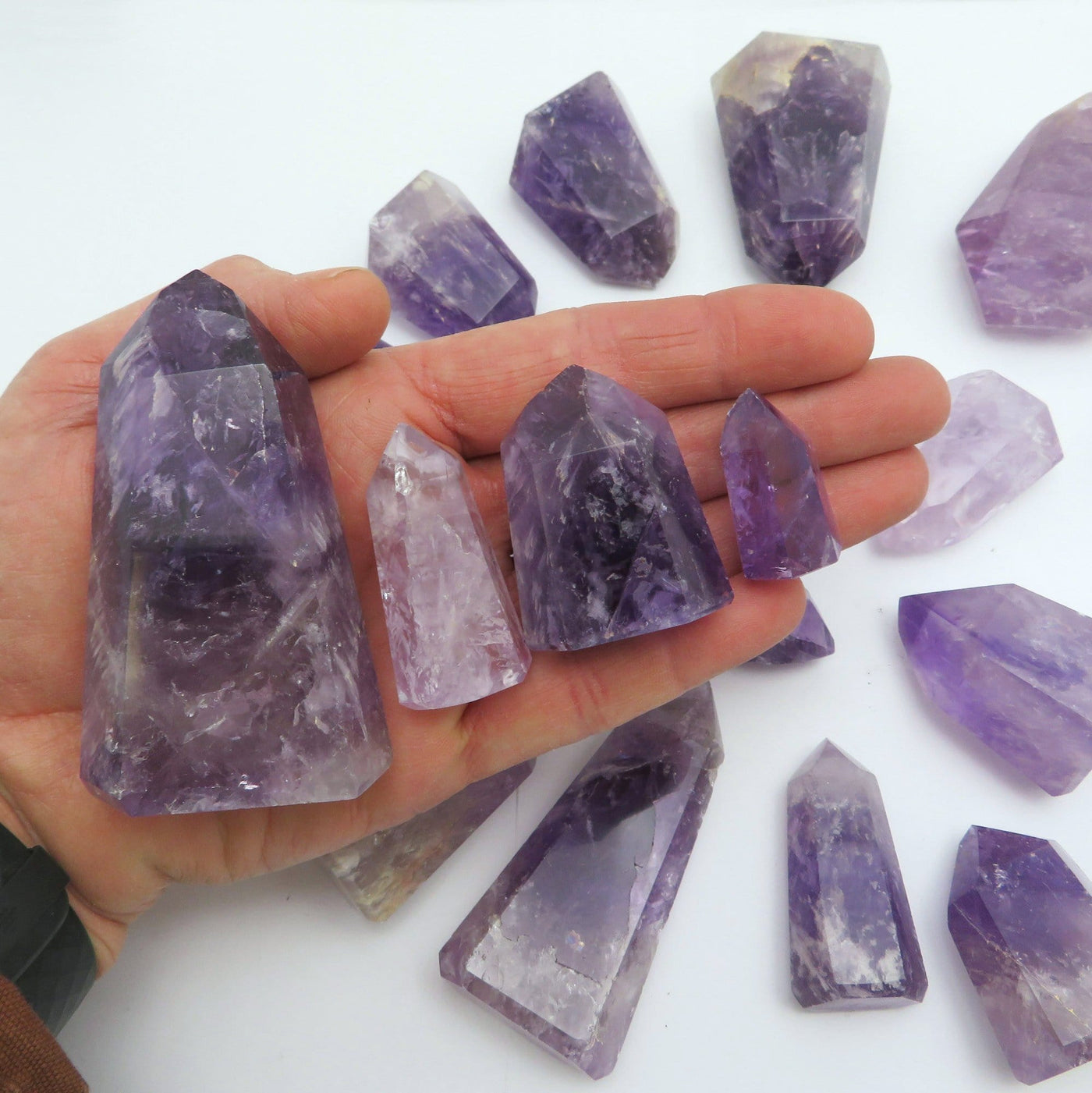 amethyst towers displayed in hand for size reference in each weight category under 40 grams 41-80 grams 81-100 grams 101-150 grams 151-200 grams