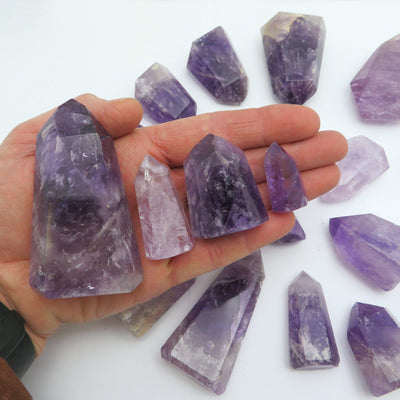 amethyst towers displayed in hand for size reference in each weight category under 40 grams 41-80 grams 81-100 grams 101-150 grams 151-200 grams