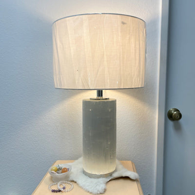 selenite lamp with silver base turned on in the dark
