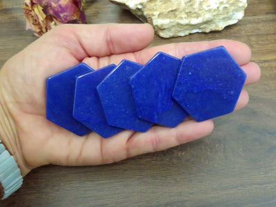 blue quartz hexagon slices displayed in hand for color variations and size reference