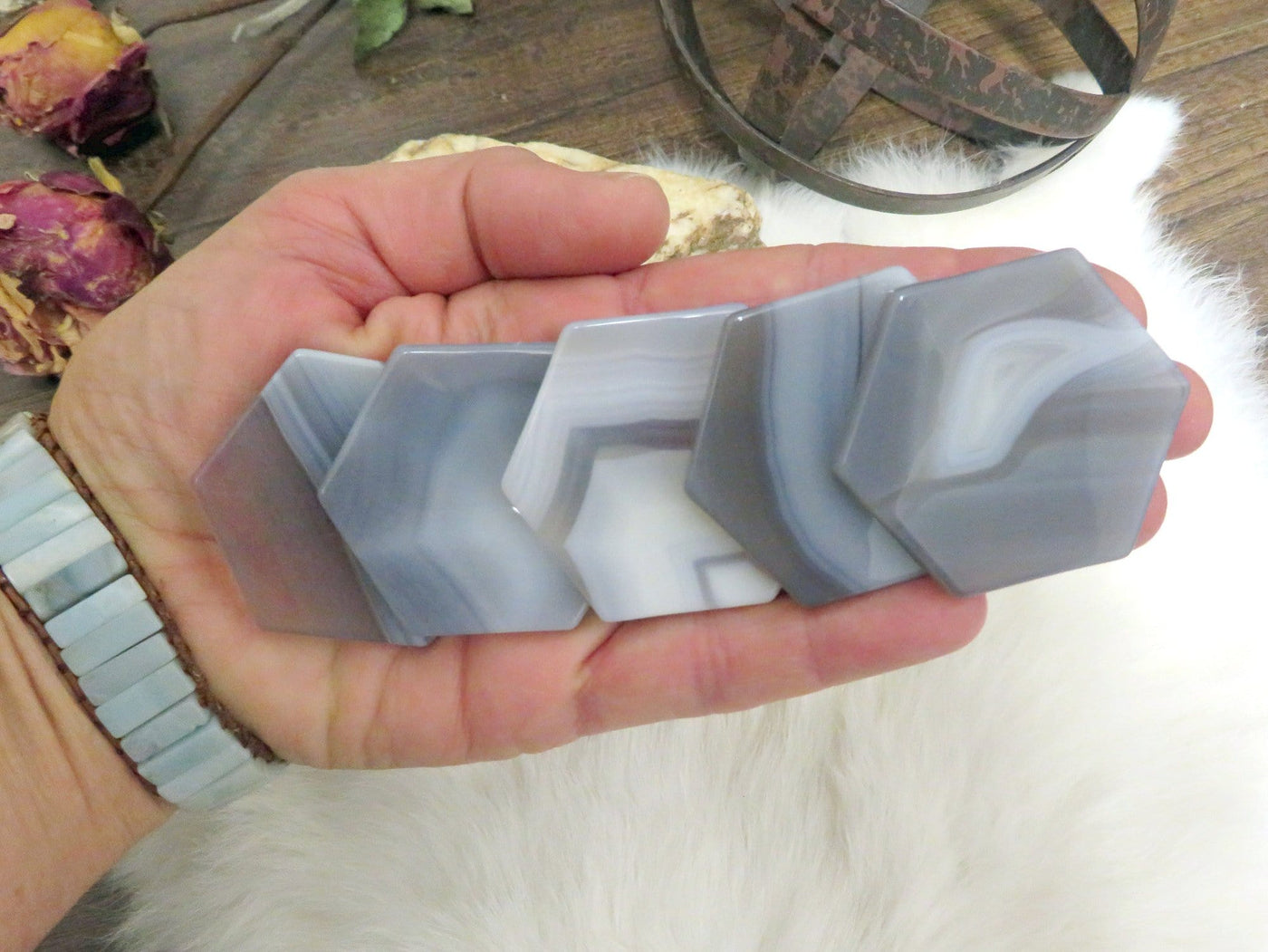 gray agate hexagon slices displayed in hand for color variations and size reference
