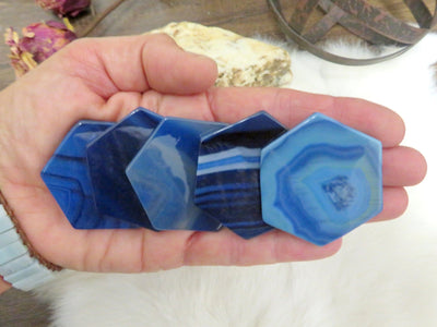 blue agate hexagon slices displayed in hand for color variations and size reference