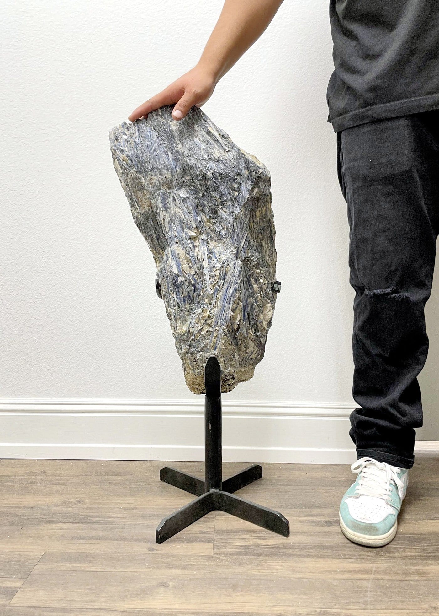 person standing next to Blue Kyanite Extra Large on metal stand 