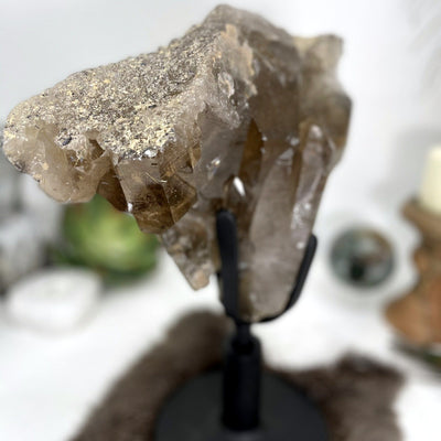 close up of smokey quartz cluster on revolving metal base for details