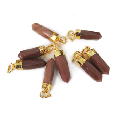 8 Jasper Spike Pendants with gold electroplated cap, laying on a table