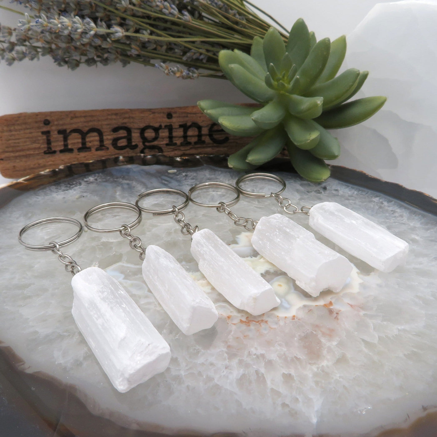 angled view of selenite silver toned key chains for thickness and possible variations
