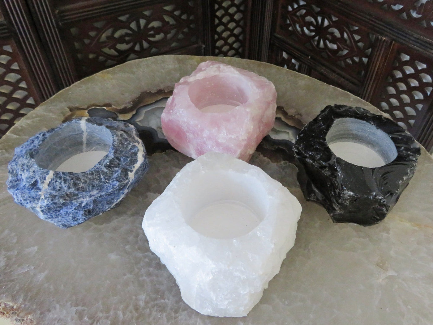 4 Rough Stone Planters of different crystals on top of crystal table top