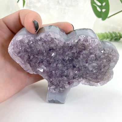 semi-polished amethyst tree shape in hand for size reference