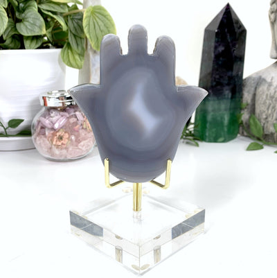 hamsa hand on display stand with white background within an alter.