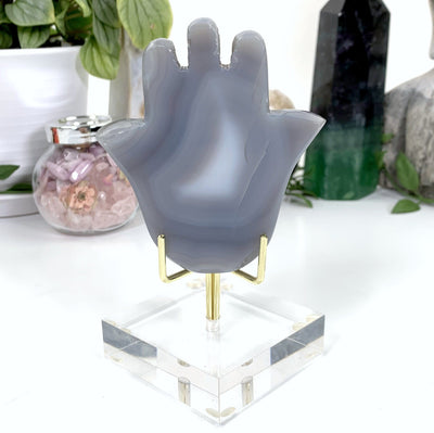 other side of hamsa hand on display stand with white background within an alter.
