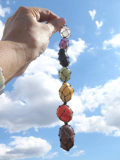 chakra stone wall hanging held outside in the natural light 
