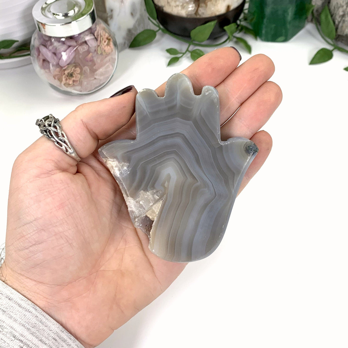 Natural Agate Hamsa Hand with Druzy Inclusion - gray with lines going through on a hand