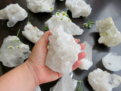 hand holding up crystal quartz cluster with others in the background