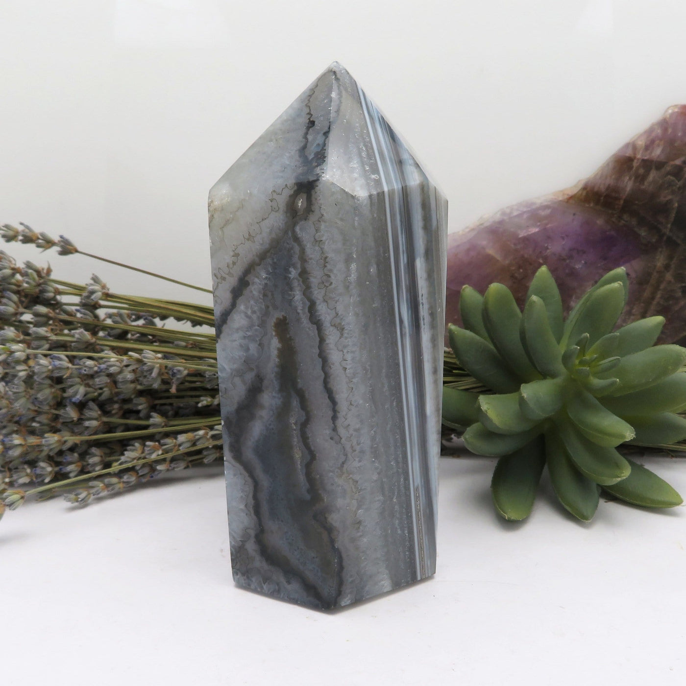 A side view of Agate Druzy Polished Point (DOOAK-S36-32) in an alter.
