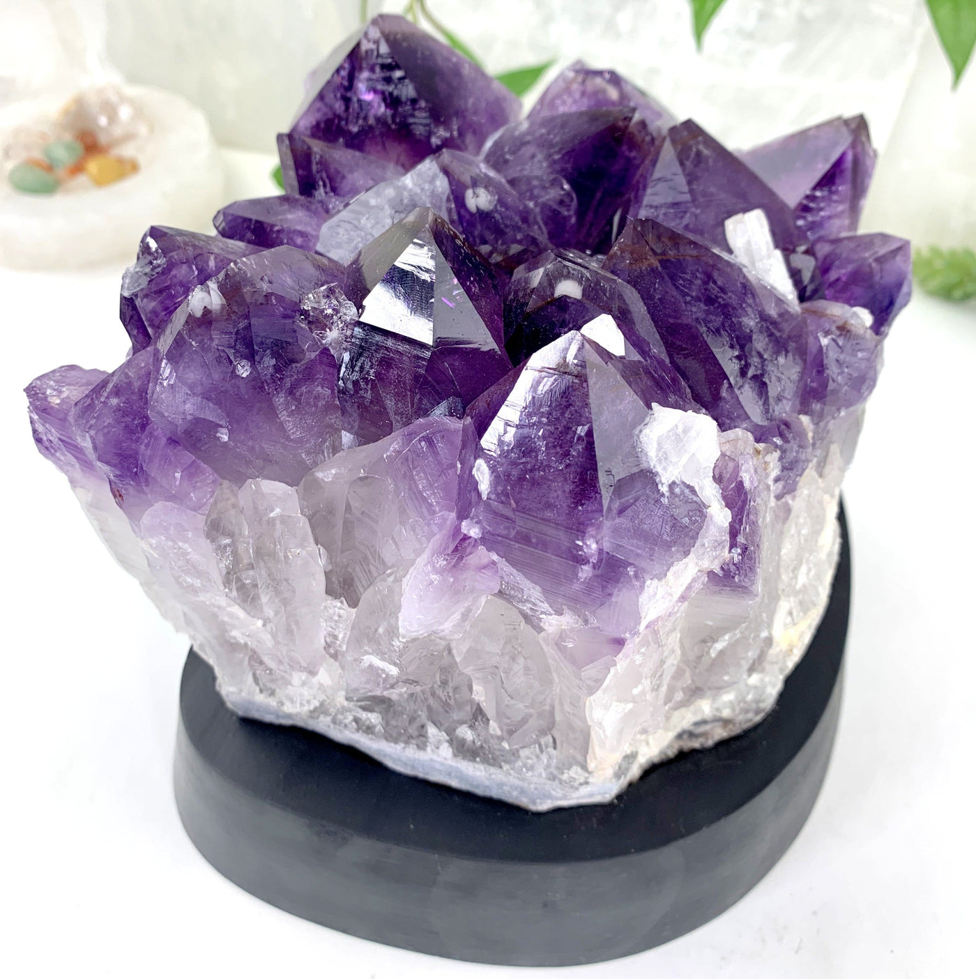 amethyst Cluster with Calcite Formations on Wood Base  with decorations in the background