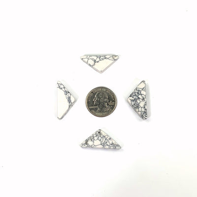 4 white howlite triangles surrounding a quarter for sizing reference