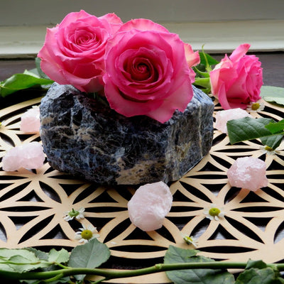 close up of one sodalite planter with three roses inside with rose quartz and rose décor surrounding it