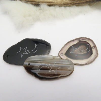 Picture of three black agate slices double drilled.