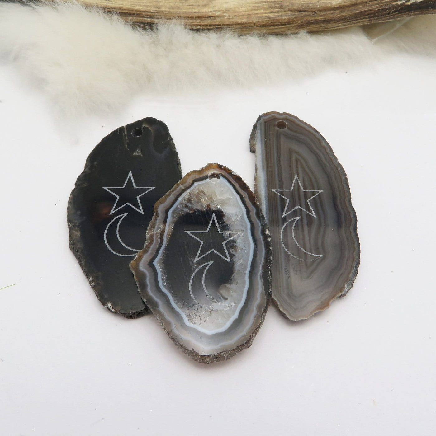 Picture of three black agate slices double drilled.