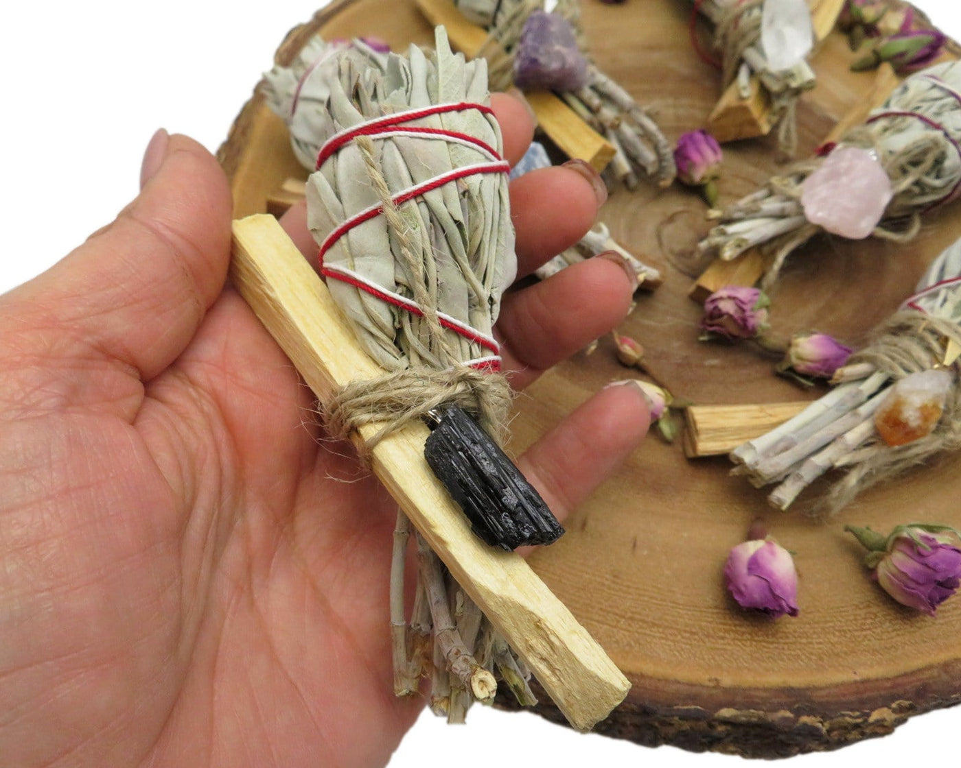 close up of sage palo santo bundle with black tourmaline pendant for size reference and possible variations