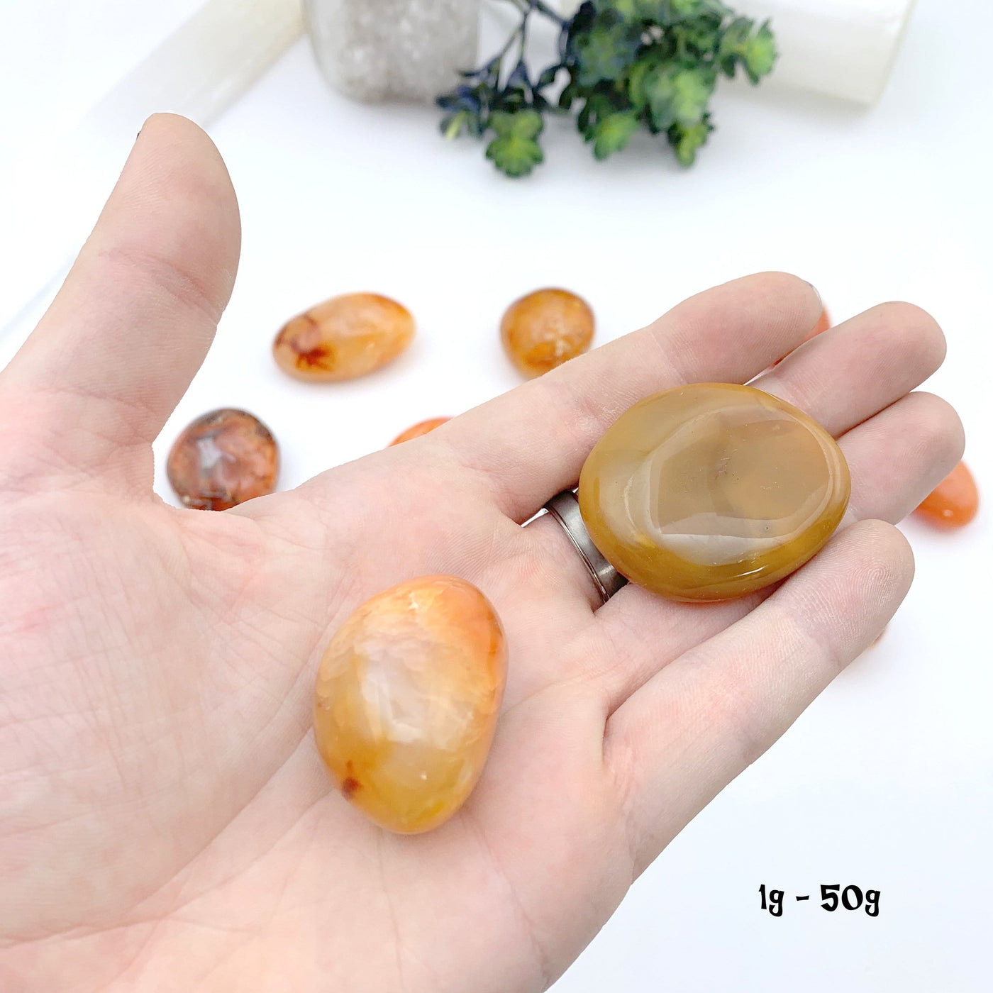 2 1gram to 50 gram carnelian stones in hand with a white background