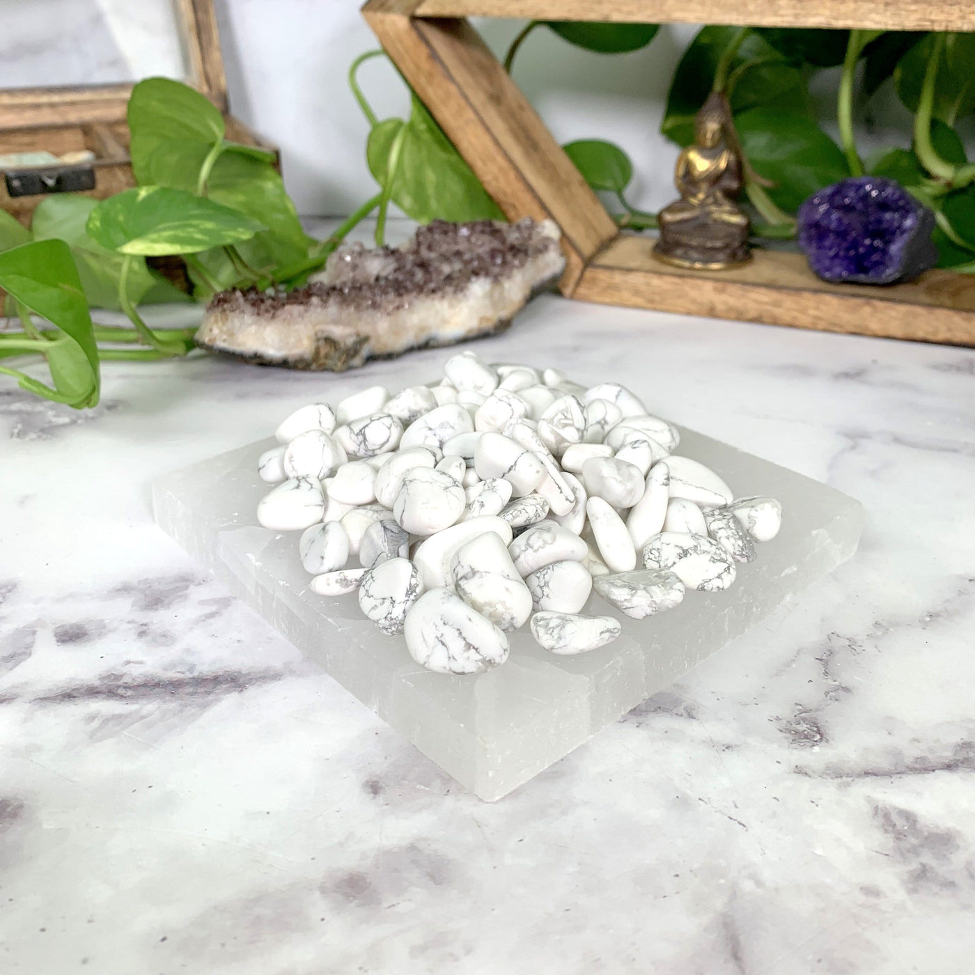 tumbled howlite stones on selenite platter with decorations in the background