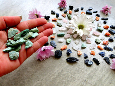 Hand holding pile of crystals in front of Rough Stone Mixed Set Crystal Grid