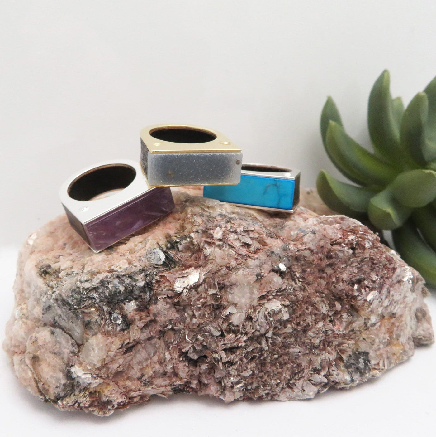 Amethyst, Druzy and Turquoise Howlite rings pictured on a black tourmaline with mica.