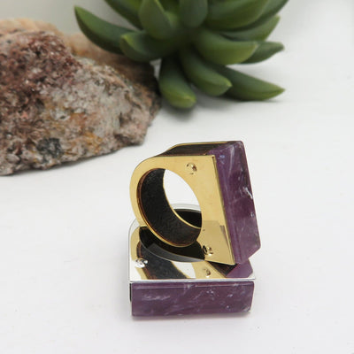 A gold and silver plated amethyst ring on a white background.