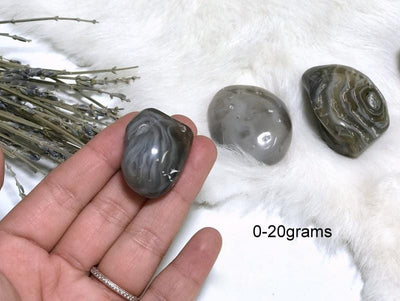 Enhydro Polished Agate Geode in fingers showing the weigh of 0 to 20g