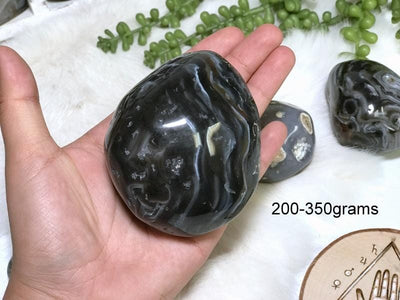 Enhydro Polished Agate Geode in hand showing the weigh of 200 to 350grams.
