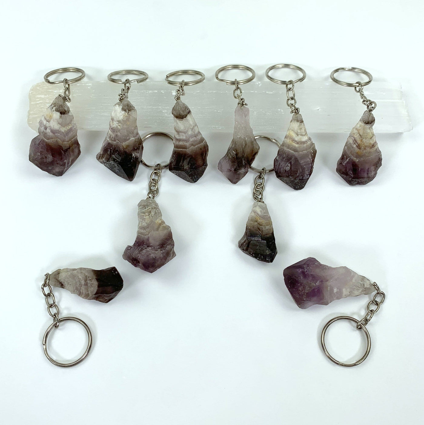 Natural Chevron Amethyst Keychains - 10 on a table