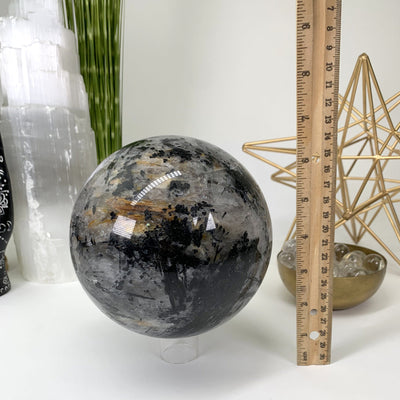 Picture of the sphere, next to a ruler for size reference. 