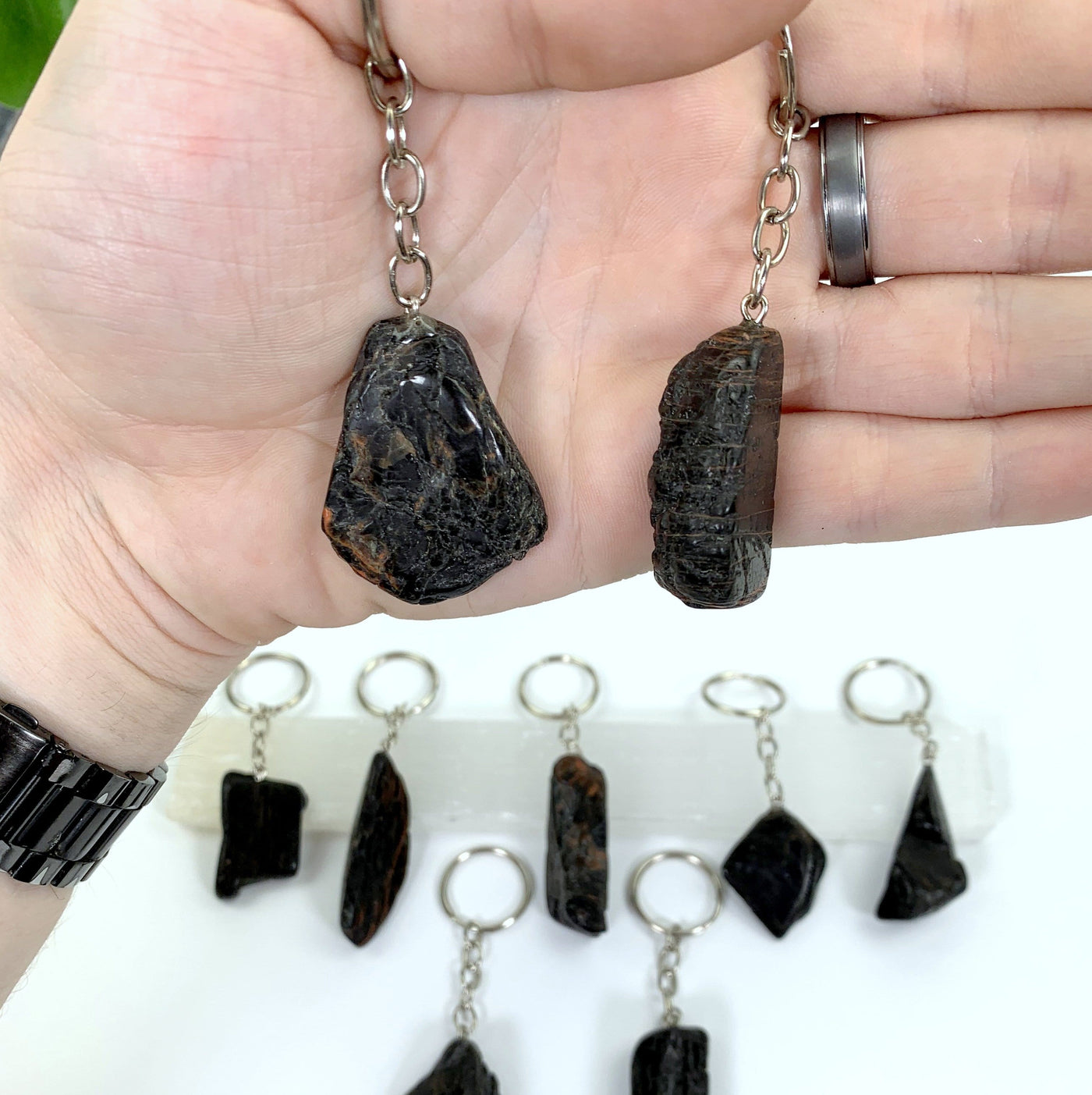 Up close view of two Polished Tourmaline with Hematite Keychains, in hand.