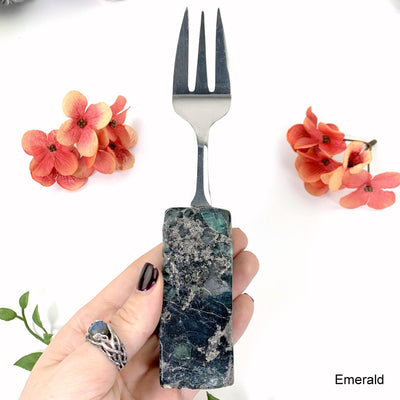 emerald fork in hand with white background